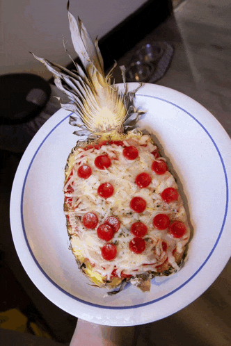 a pineapple shaped pizza with pepperoni and cheese on a white plate