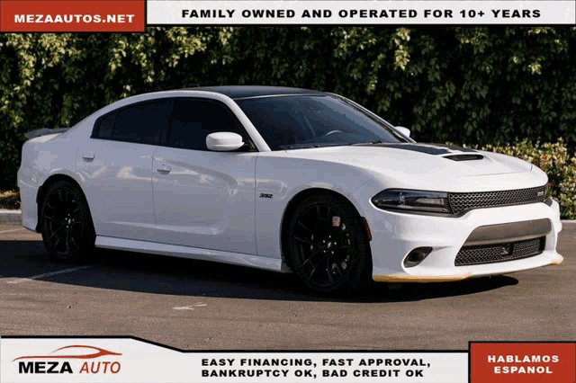 a white dodge charger sits in a parking lot