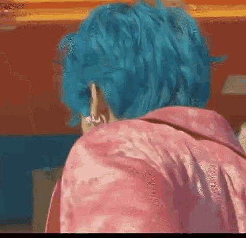 a person with blue hair is wearing a pink shirt and earrings .