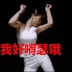 a woman in a white tank top and white pants is dancing in front of a black background with chinese writing on it