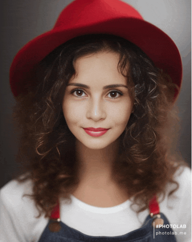 a woman wearing a red hat and overalls has a photo lab watermark on her face