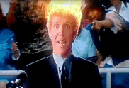 a man in a suit and tie is talking into a microphone with a fireball in his head .