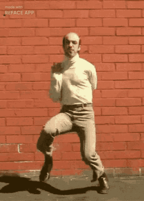 a bald man is dancing in front of a red brick wall with the words made with reface app on the bottom