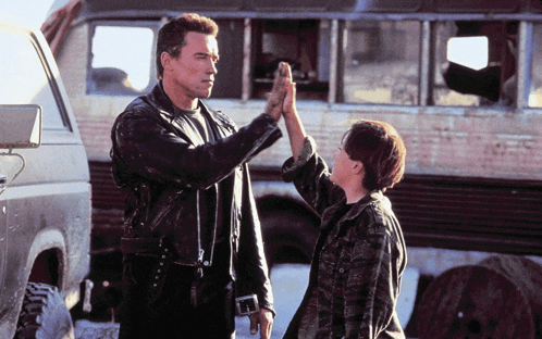 a man in a leather jacket gives a high five to a young boy