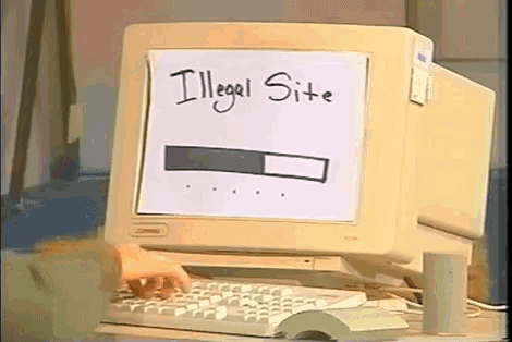 someone is typing on a keyboard in front of a computer monitor that says illegal site on it