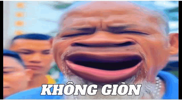 a man with a beard is making a funny face with his mouth open and the words không gion written below him .