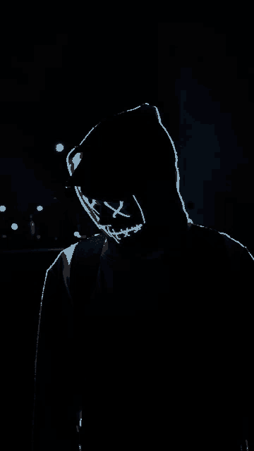 a person wearing a neon mask in the dark