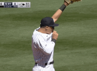 a new york yankees baseball player catches a ball during a game