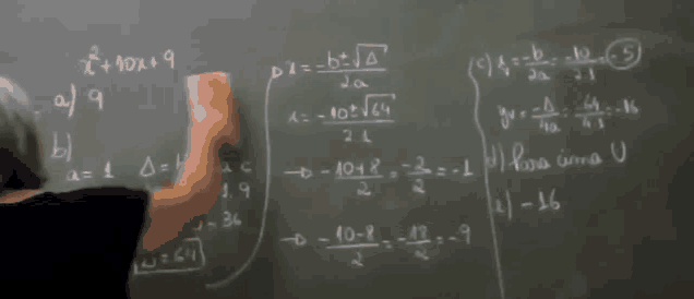 a woman is writing on a blackboard with algebra problems