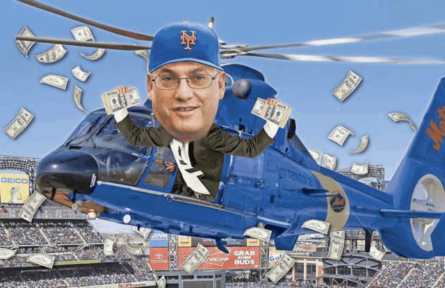 a man in a mets hat is flying in a helicopter with money falling around him