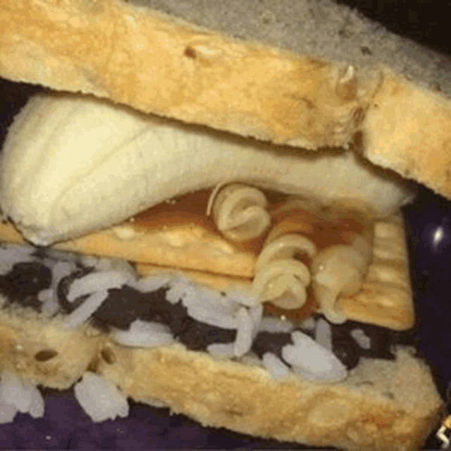 a close up of a sandwich with a banana , macaroni and cheese , and rice on a plate .