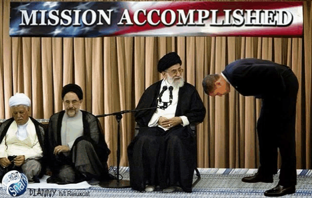 a man bows in front of a mission accomplished sign