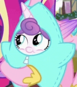 a close up of a cartoon character wearing a unicorn costume and holding a pillow .