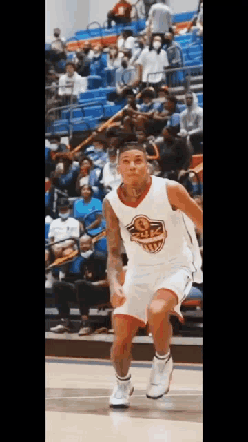 a basketball player is dribbling the ball on a court while a crowd watches .