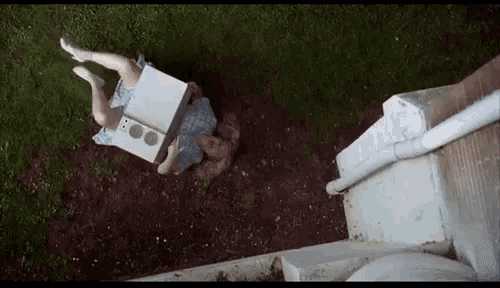 a woman in a blue dress is laying on the ground holding a white box with a speaker on it