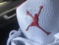 a close up of a white shoe with a red jumpman logo on it .