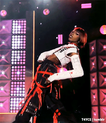 a woman is dancing on a stage in front of a wall of lights .