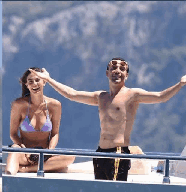 a shirtless man and a woman in a bikini are sitting on a boat