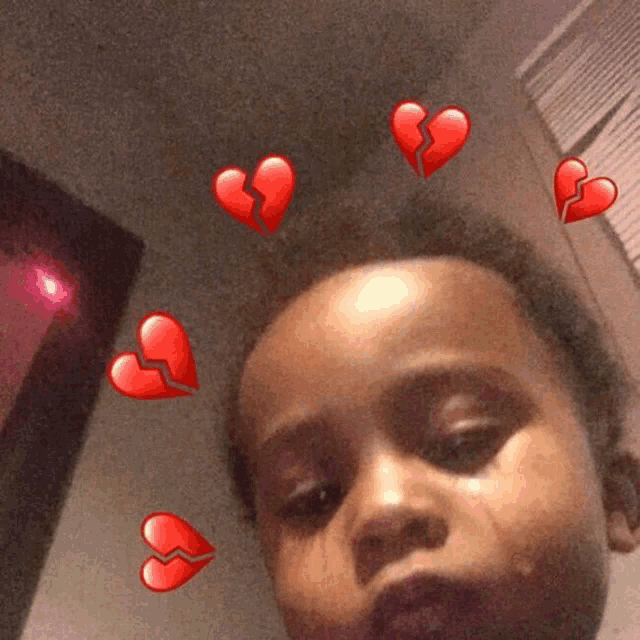 a young girl is taking a picture of herself with broken hearts around her head .