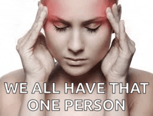 a woman with a headache is holding her head in pain .