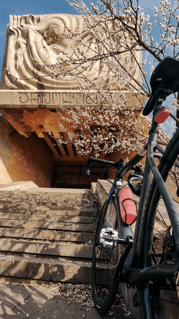 a bicycle is parked in front of a building with a statue on the front that says ' o'ahu '