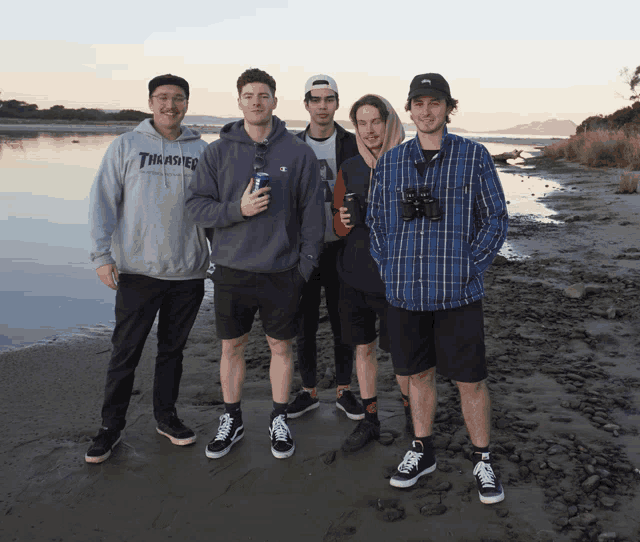 a man wearing a thrasher hoodie poses for a photo with his friends