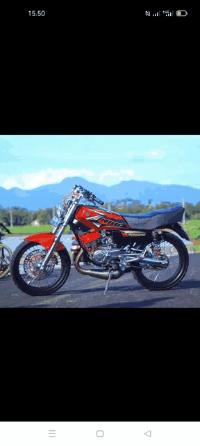 a red and black motorcycle is parked on the side of the road .