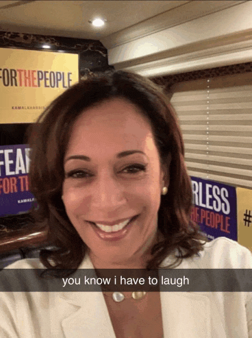 a woman is smiling in front of a sign that says for the people