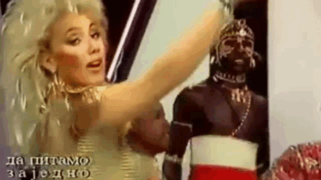 a woman is dancing in front of a statue of a man in a costume .