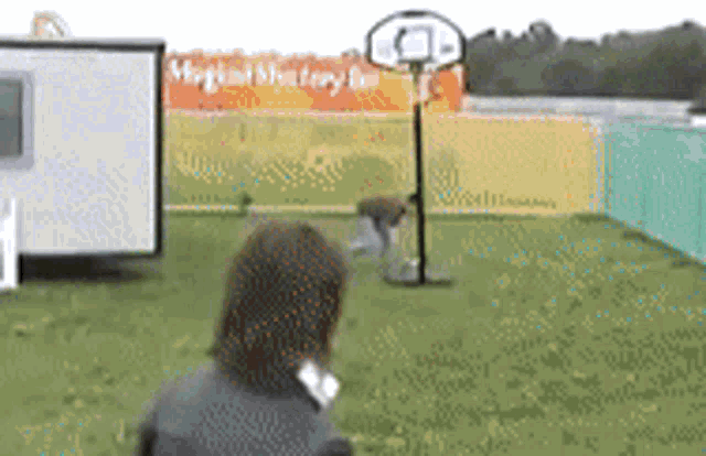 a woman stands in front of a basketball hoop with a sign in the background that says magical mystery land