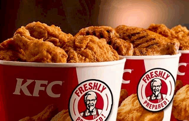 three buckets of kfc fried chicken are lined up in a row