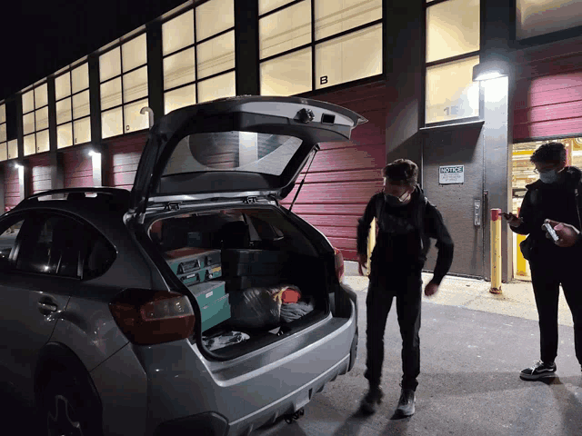 a man standing next to a car with the trunk open and a sign that says police on it