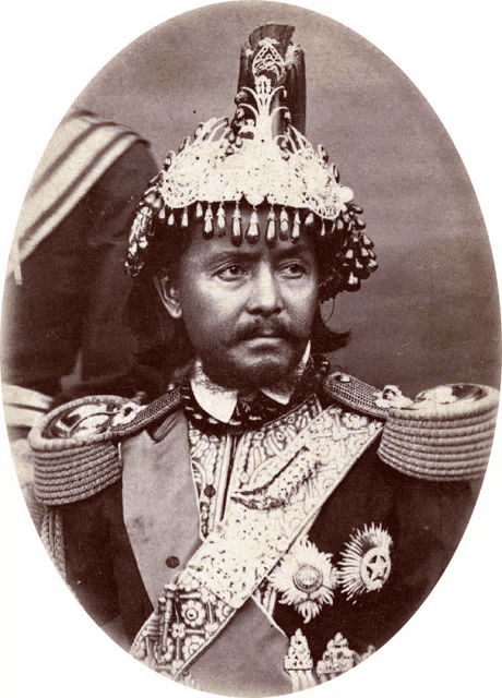 a black and white photo of a man wearing a very elaborate hat