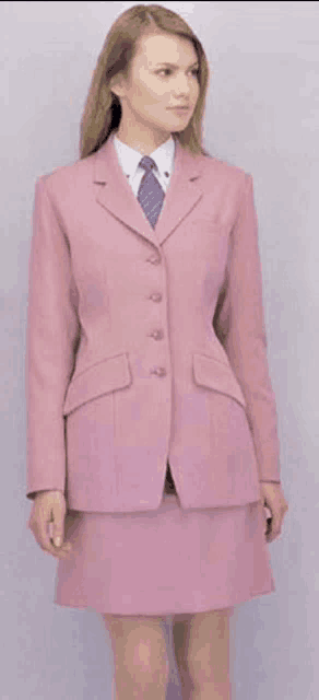 a woman wearing a pink suit and tie