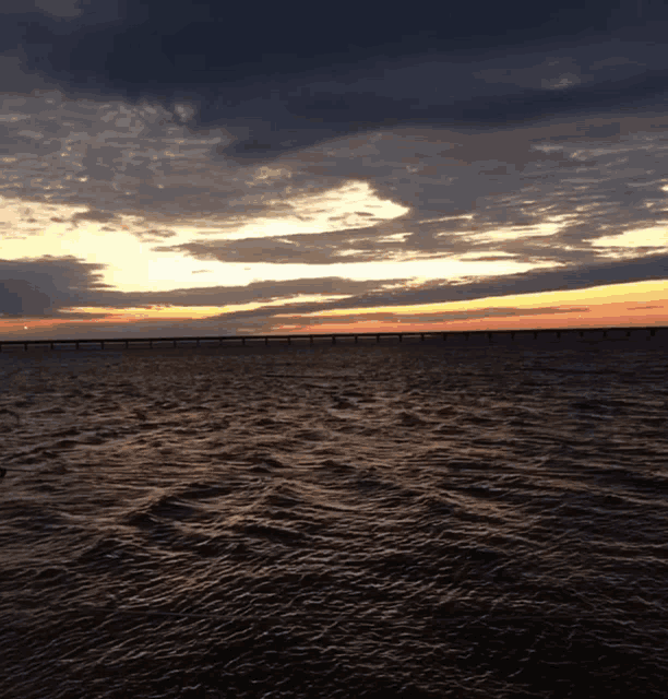 a large body of water with a bridge in the distance