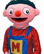 a stuffed animal wearing overalls and a red shirt with a m on it .