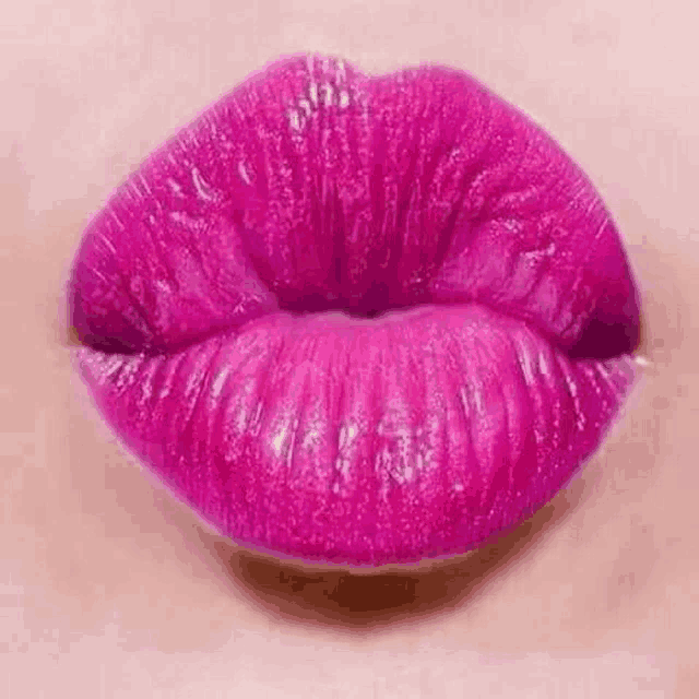 a close up of a woman 's lips with pink lipstick on .