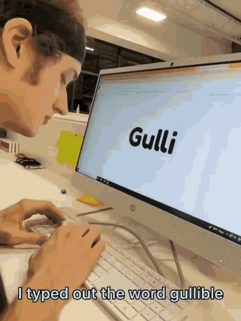 a man types out the word gullible on a computer screen