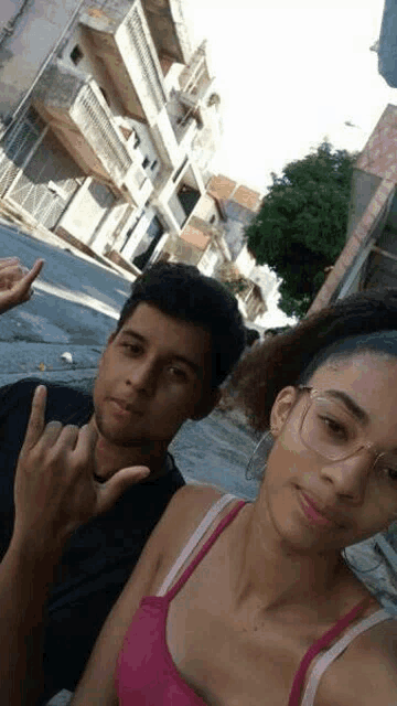 a boy and a girl are standing next to each other on a sidewalk .