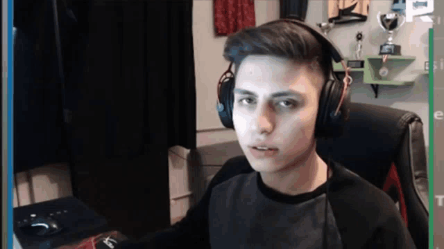 a young man wearing headphones sitting in front of a computer monitor