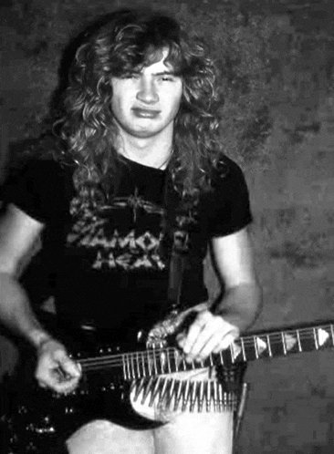 a black and white photo of a man holding a guitar .