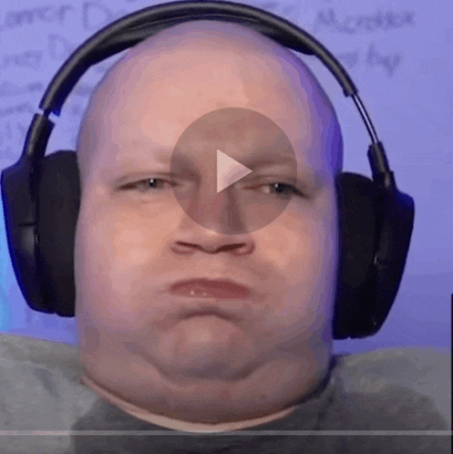 a bald man wearing headphones looks at the camera