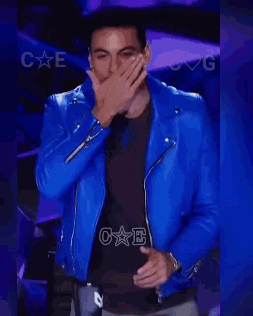 a man wearing a blue leather jacket with the letters c e and c g on it