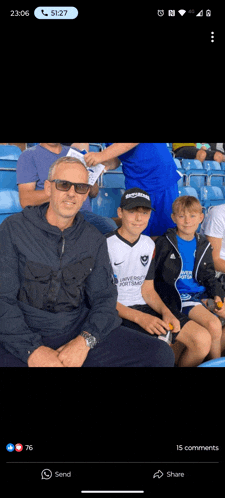 a group of people sitting in a stadium with one wearing a jersey that says university of portsmouth