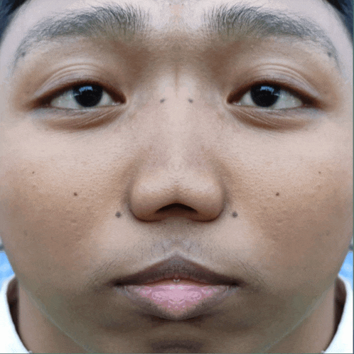 a close up of a young man 's face with a piercing in his lip