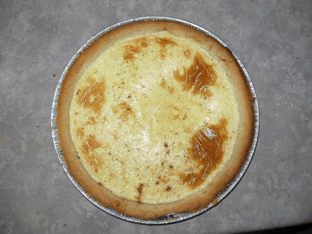 a pie in a tin foil container with a brown crust