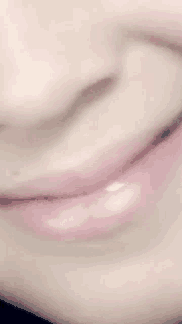 a close up of a person 's mouth with pink lips and a nose .