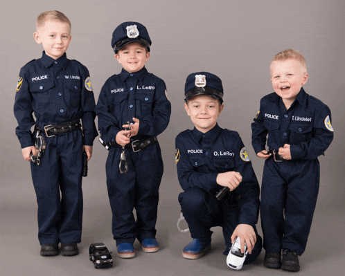 four young boys dressed up as police officers posing for a photo