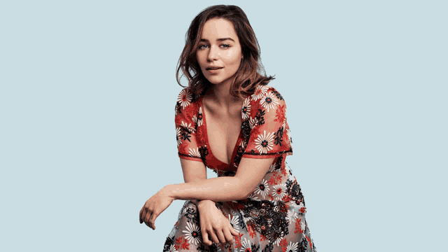 a woman in a floral dress with a plunging neckline is posing for a picture