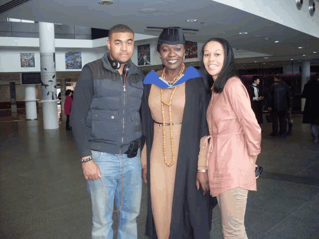 a woman in a graduation cap and gown poses for a photo